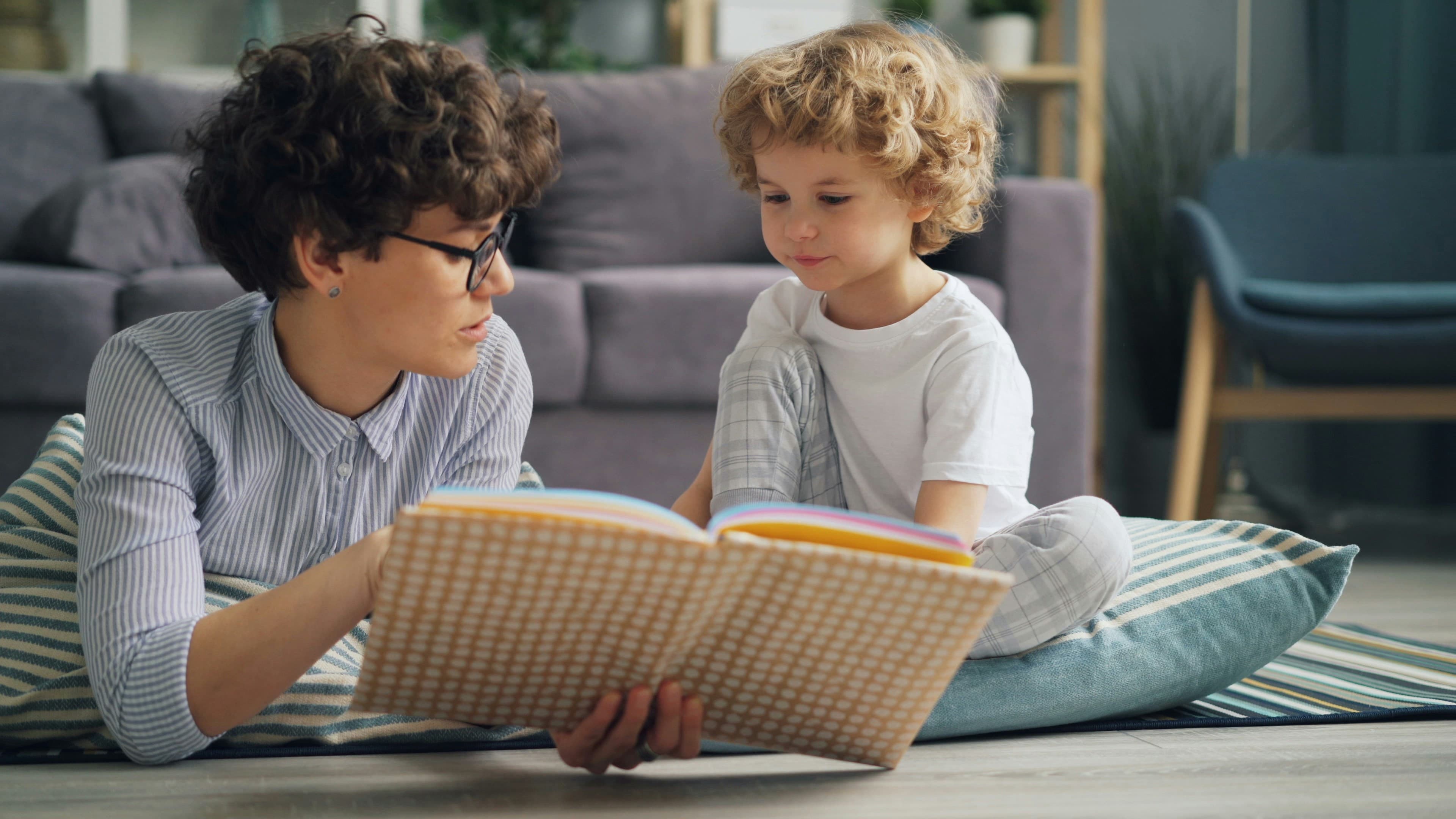 An adult and a child reading a picture book together